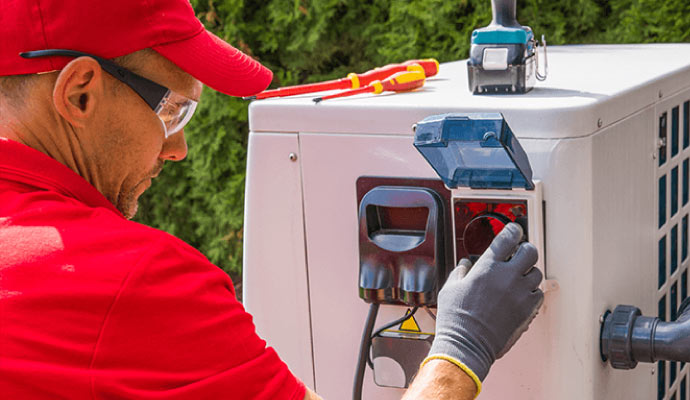 A person performing maintenance on a generator