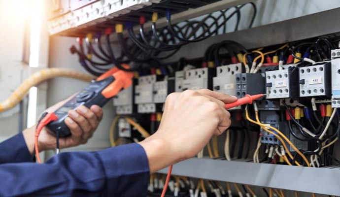 Professional inspecting electrical connections on a circuit breaker panel